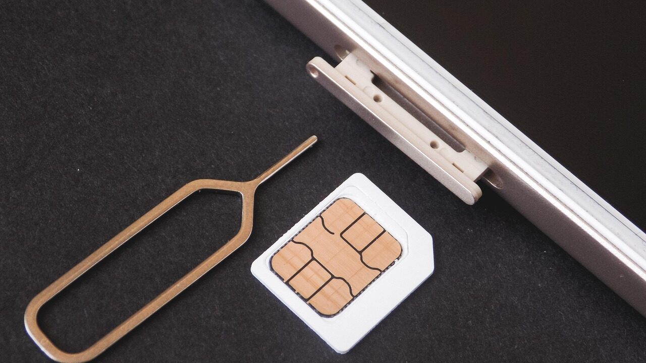 スマートフォンのSIMトレイにSIMカードを挿入する様子