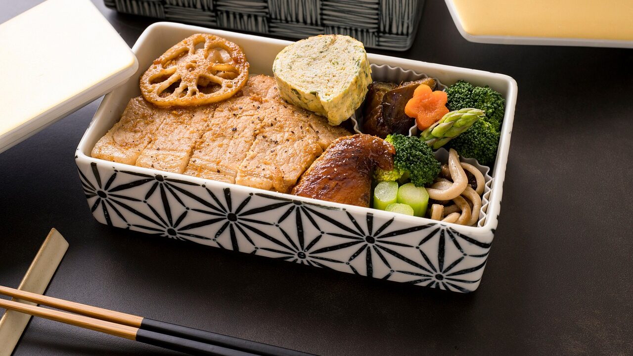 豚肉のソテーや卵焼き、ブロッコリーが詰められた和柄のお弁当