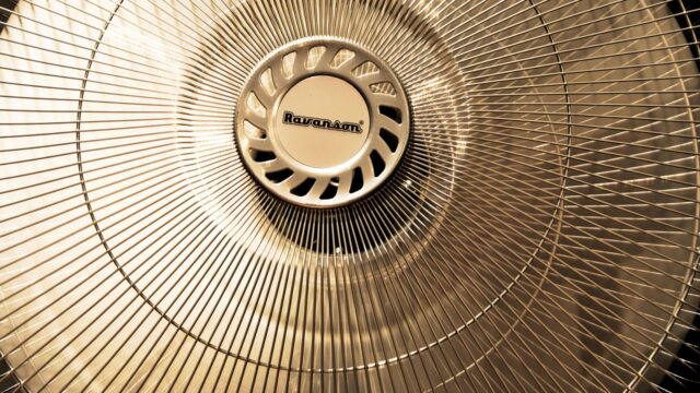 暑い部屋で回る扇風機、夏の節電イメージ