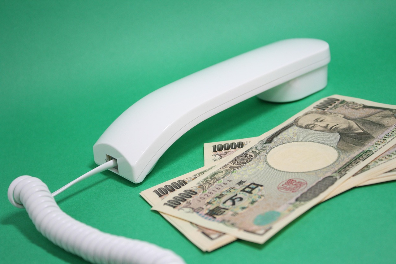 日本円の紙幣と電話の受話器