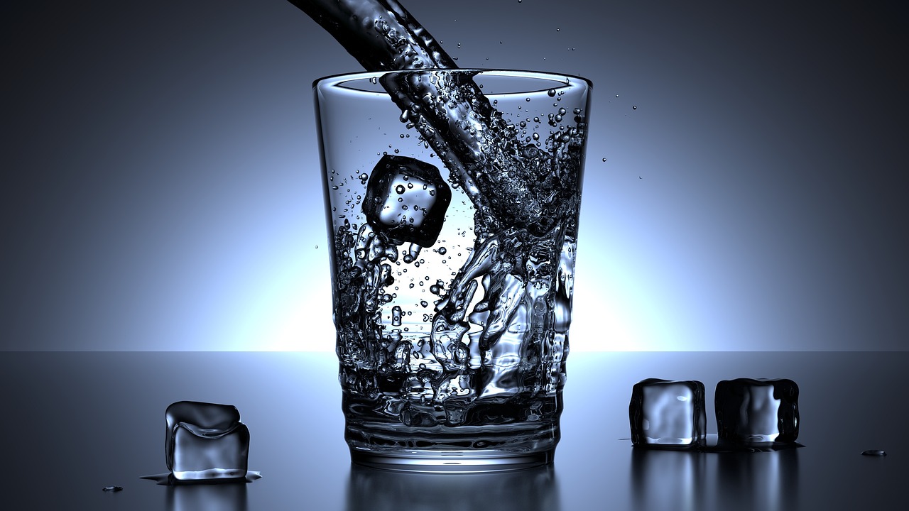 透明なグラスに冷たい水を注ぐ様子