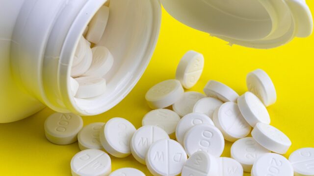 白い錠剤がボトルからこぼれ出ている様子