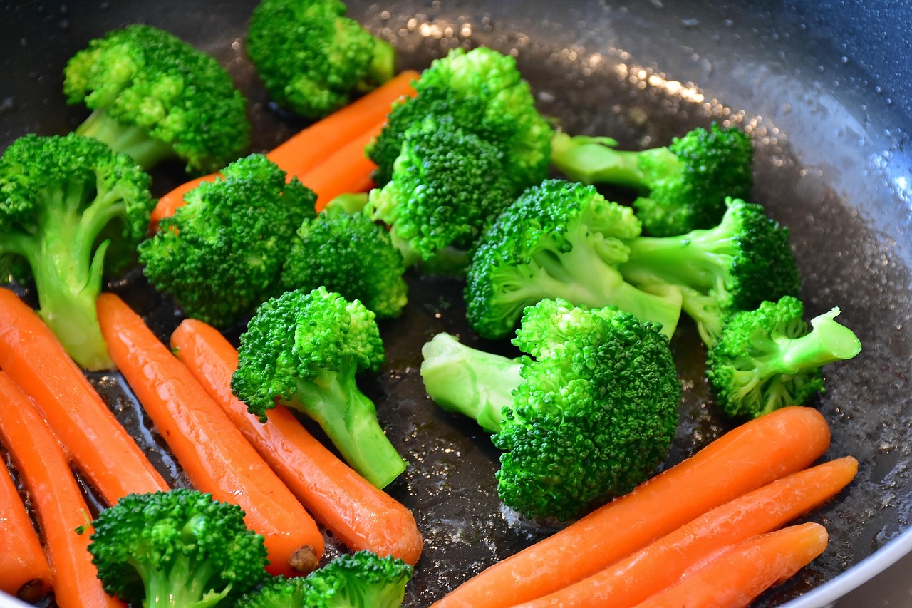 フライパンで炒められている彩り豊かな野菜(ブロッコリーとにんじん)