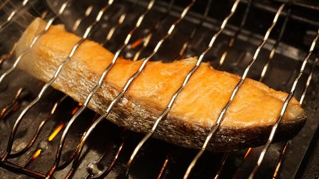 網の上で焼かれている魚の切り身、DHA・EPAを含む和食の食卓イメージ