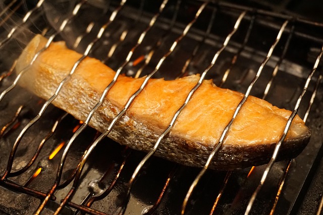 網の上で焼かれている魚の切り身、DHA・EPAを含む和食の食卓イメージ