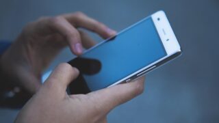 スマートフォンを両手で操作している様子