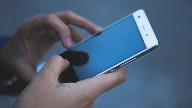 スマートフォンを両手で操作している様子