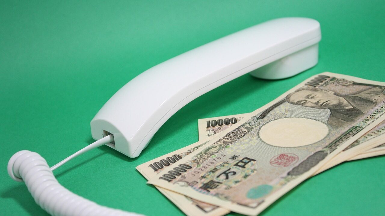 1万円札と電話の受話器の写真、家計相談のイメージ
