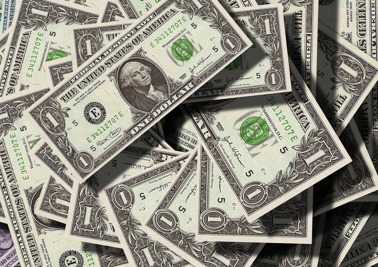 重なり合った1ドル紙幣の写真、米国の金利や海外のお金の動きをイメージ