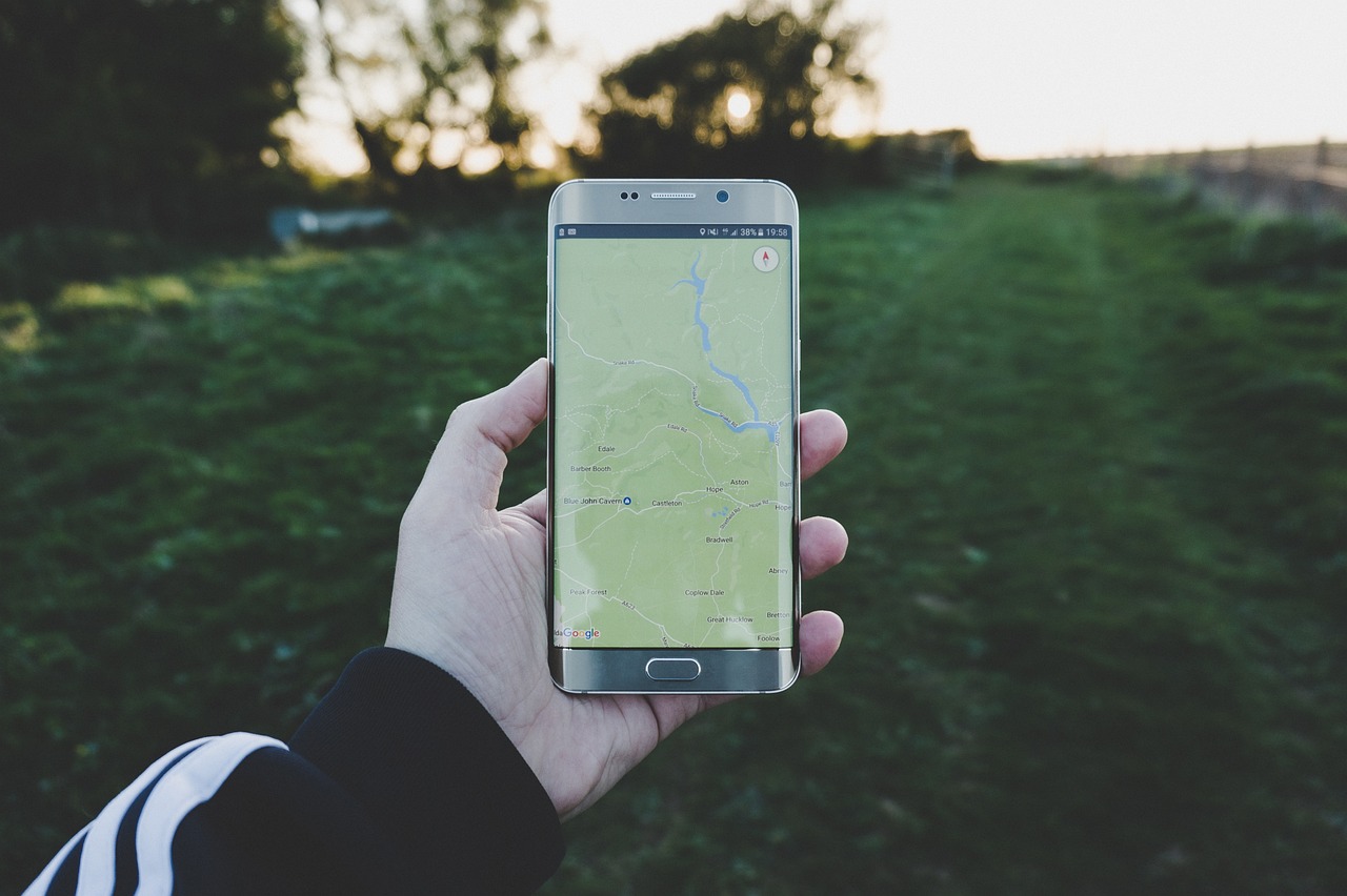 屋外でスマートフォンの地図アプリを表示している手元