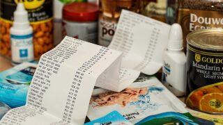 値上がりした食品や日用品とレシートが並ぶ様子