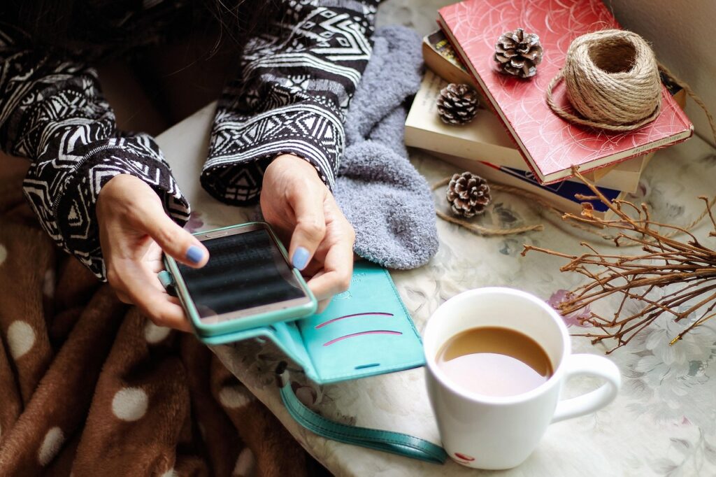 自宅でスマートフォンを操作しながら考え込んでいる様子