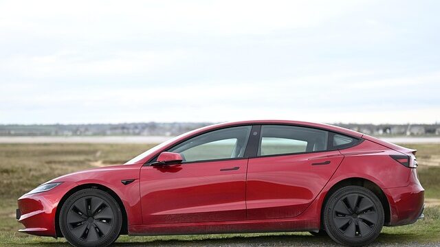 赤いテスラの電気自動車を横から見た外観