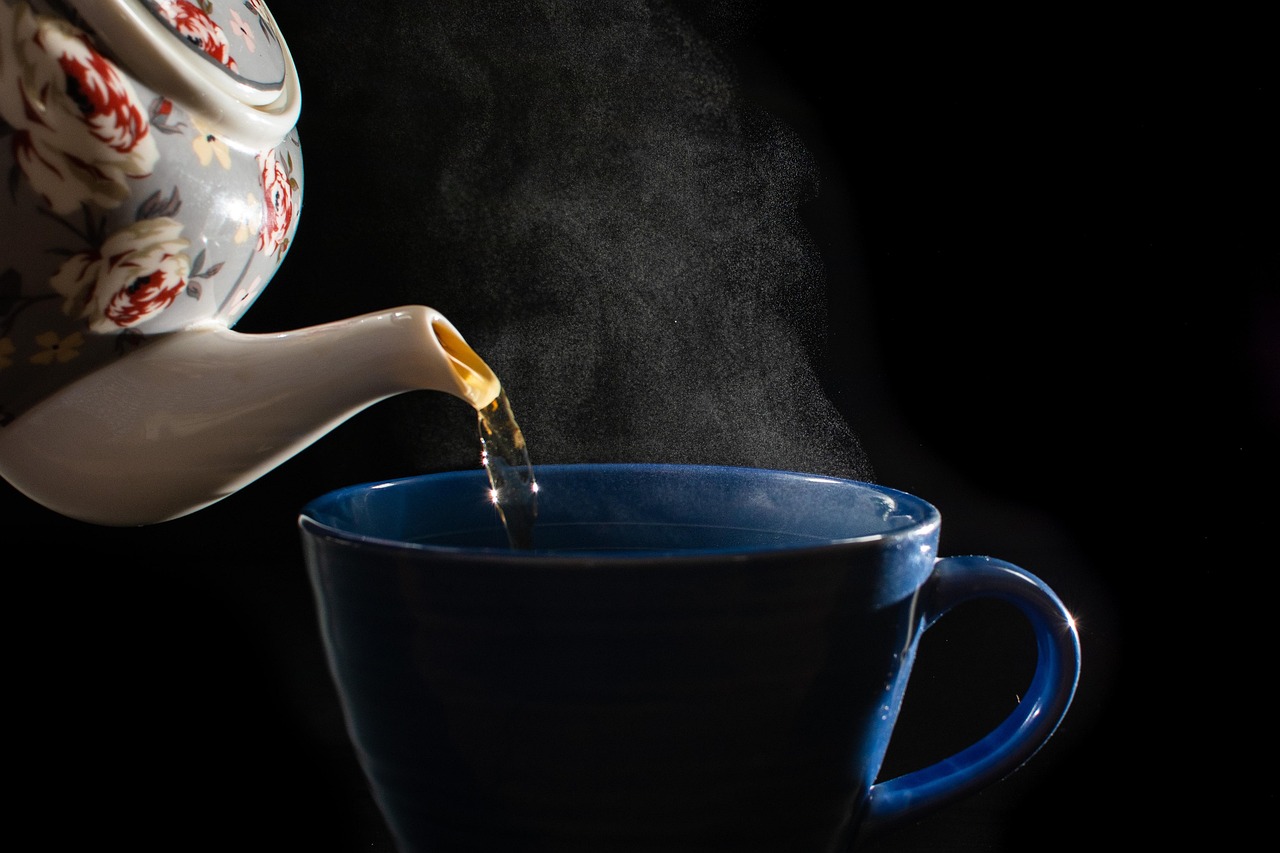 湯気を立てながらティーポットから温かいお茶を注いでいる様子