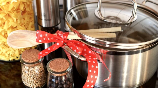 キッチンのコンロに置かれた鍋と木べら、食事の準備のイメージ