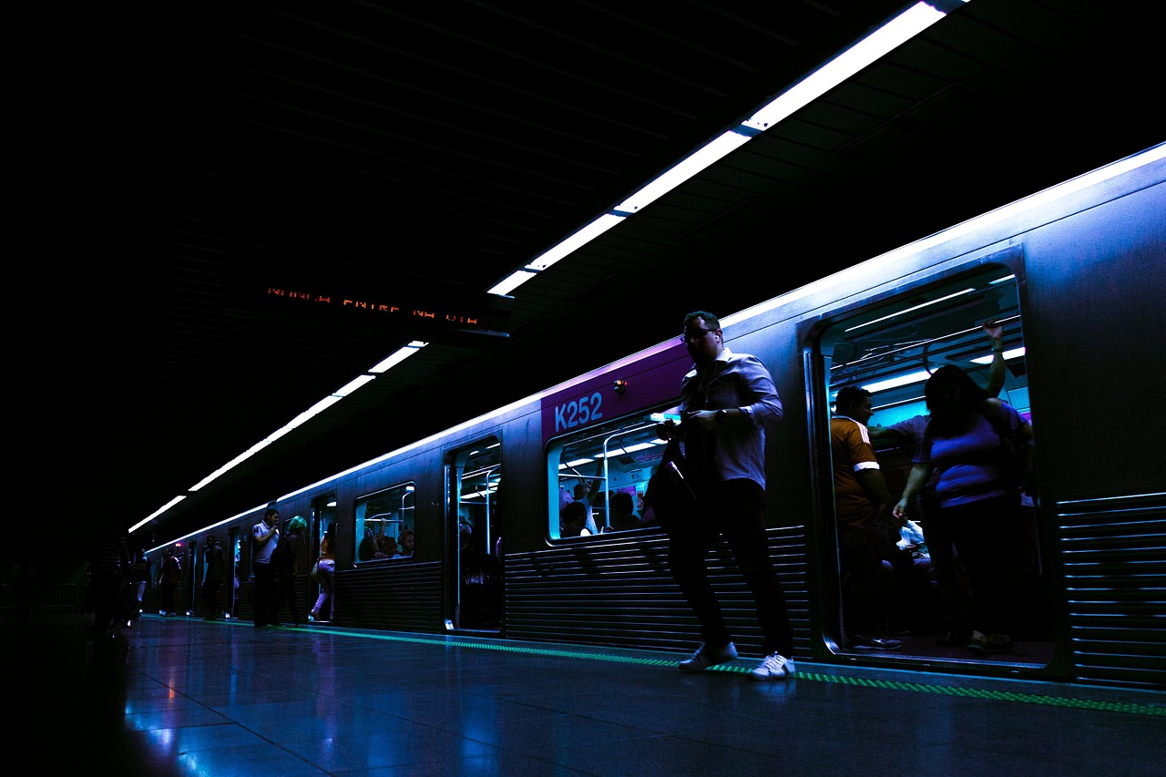 夜の駅のホームで電車に乗り降りする人たち