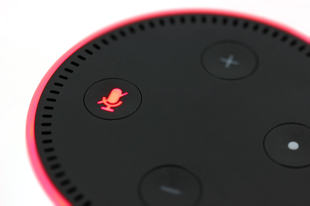 マイクのボタンが赤く光っている、丸いスマートスピーカーの上面のアップ