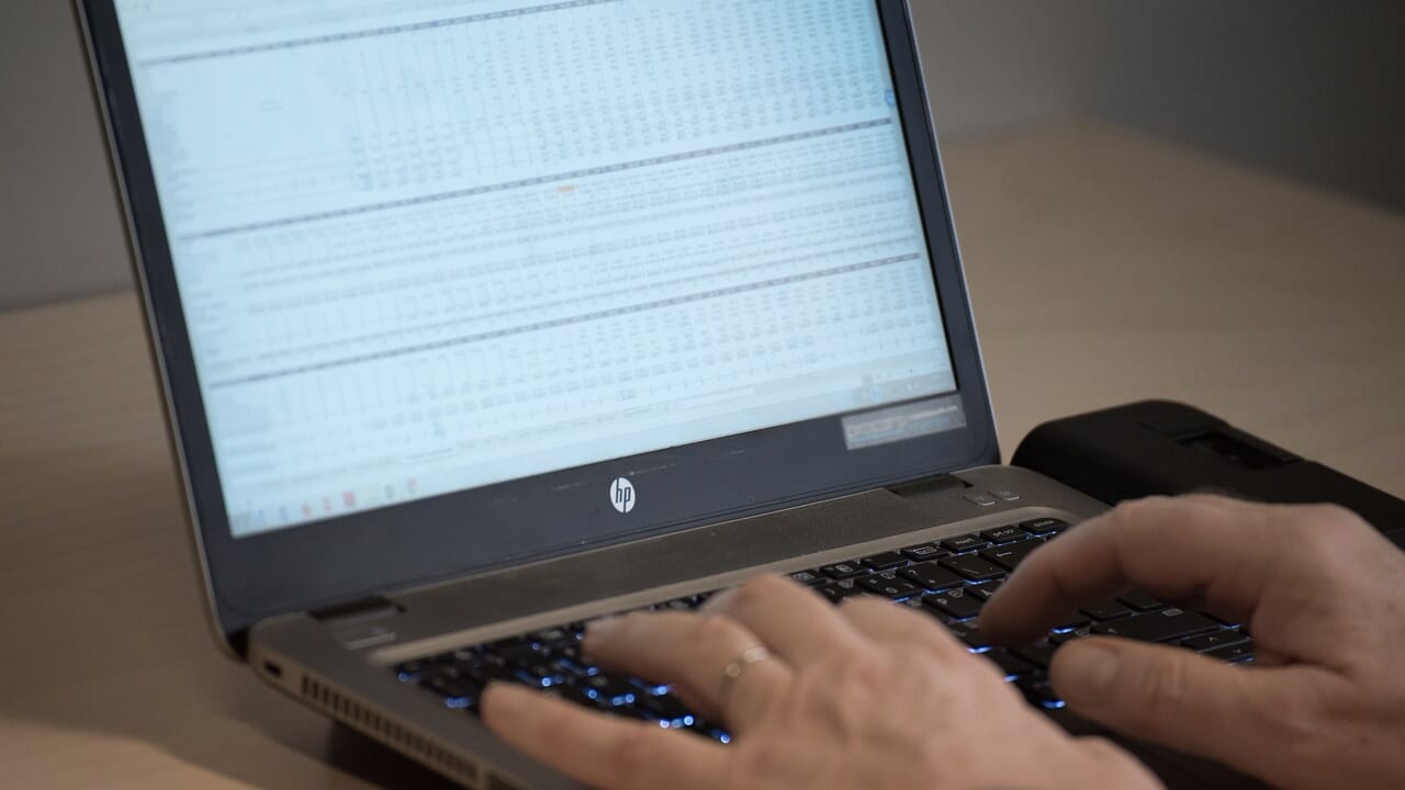 ノートパソコンで表計算の画面を開き、キーボードを打つ手元
