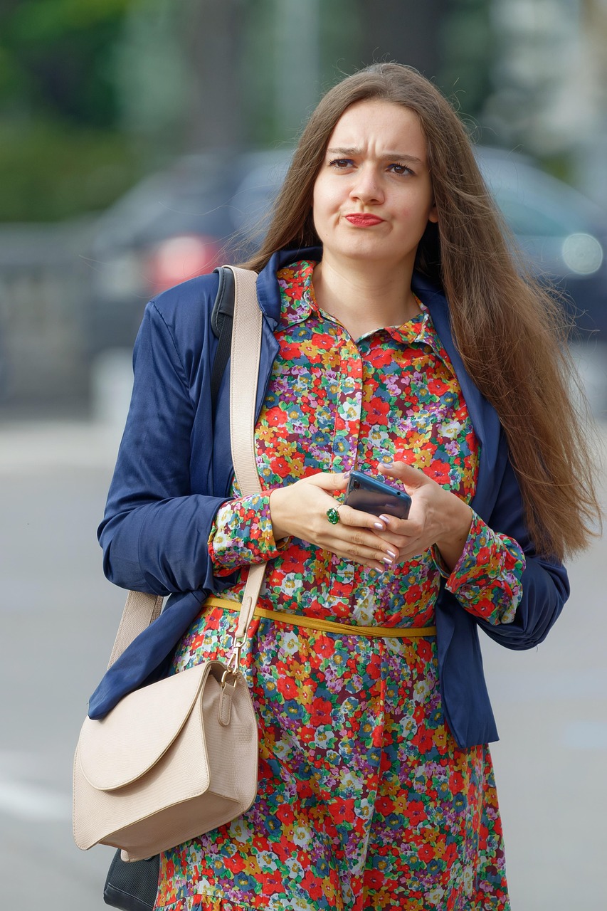 スマートフォンを手に困った表情を浮かべる女性