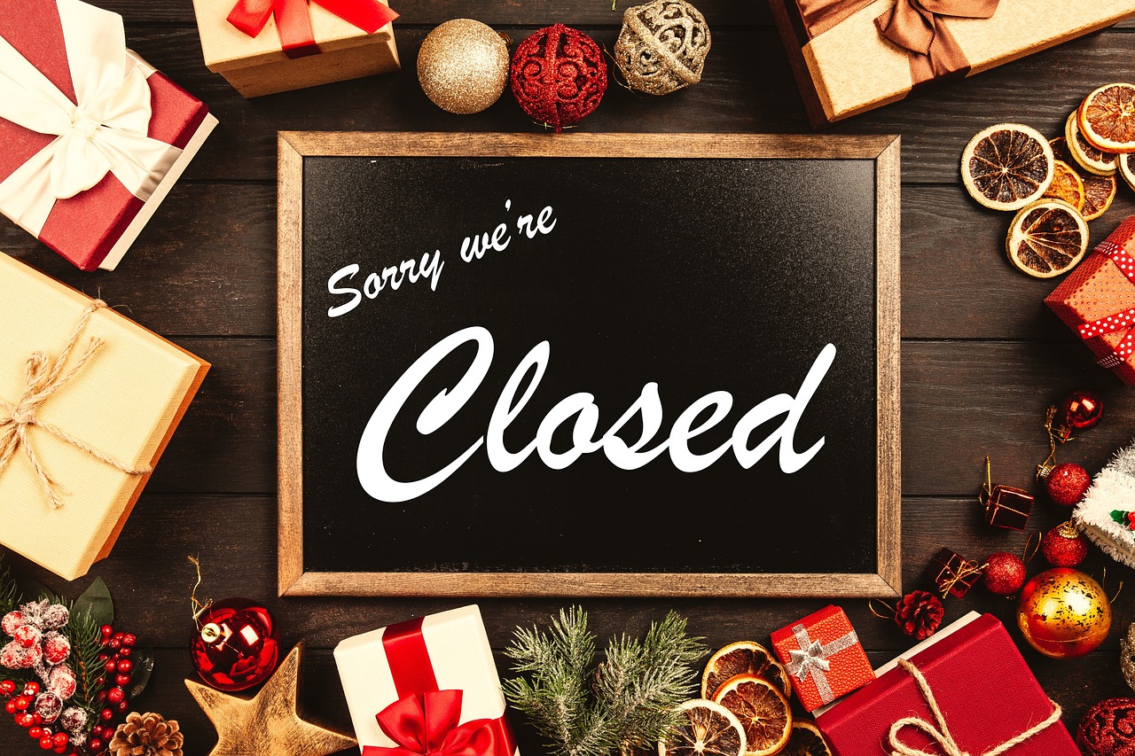 クリスマスの飾りやプレゼントに囲まれた「Sorry we're closed」の黒板