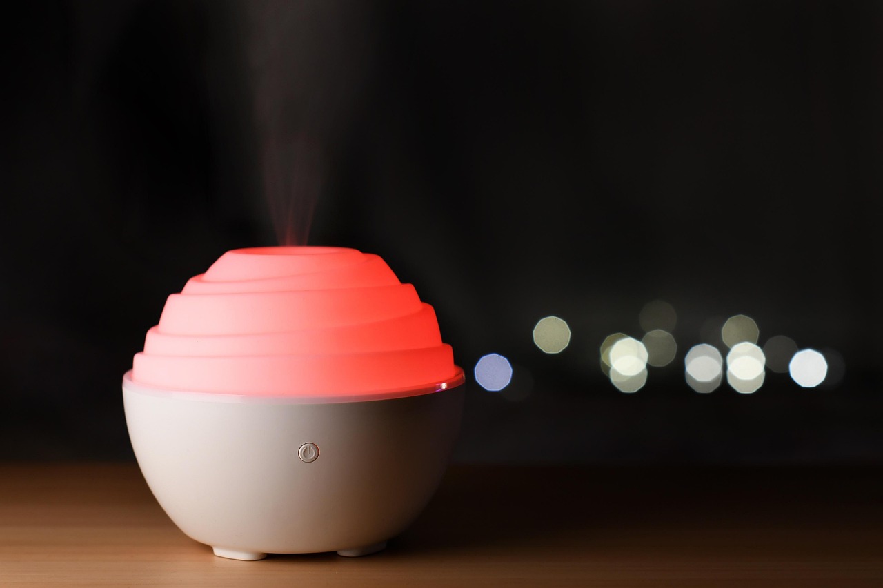 夜の部屋で白いミストを出している卓上の加湿器