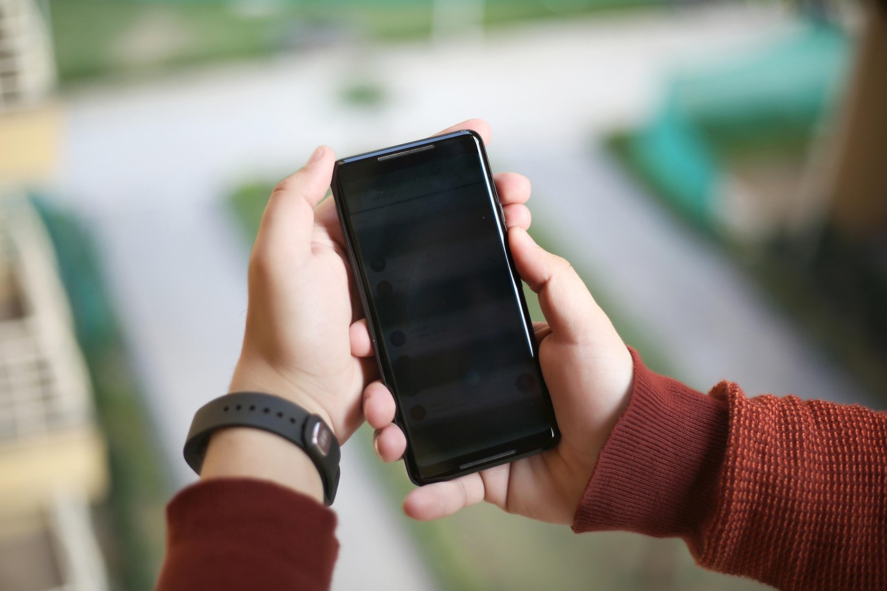 両手でAndroidスマートフォンを操作する様子