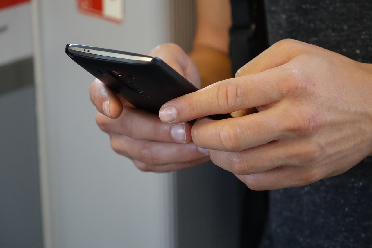 両手でスマートフォンを操作する手元