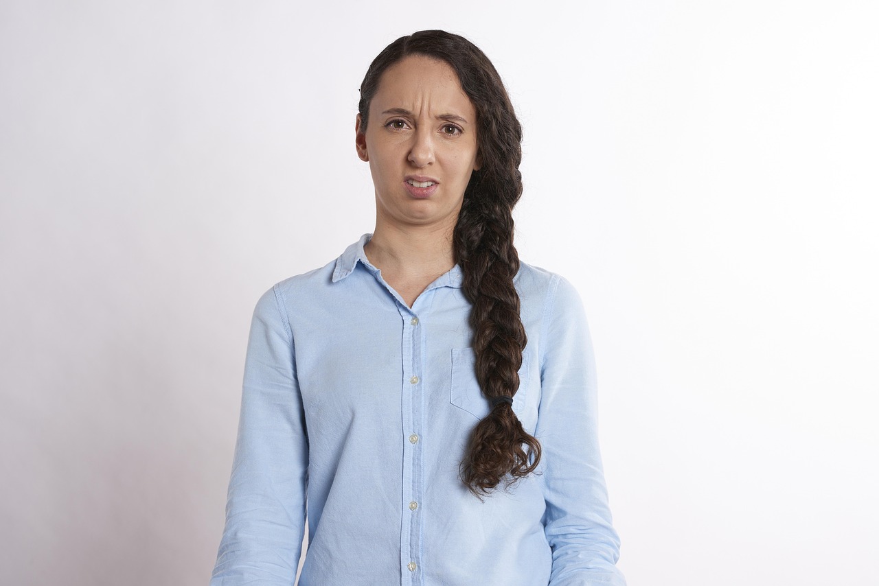 納得がいかない様子で眉をひそめる女性