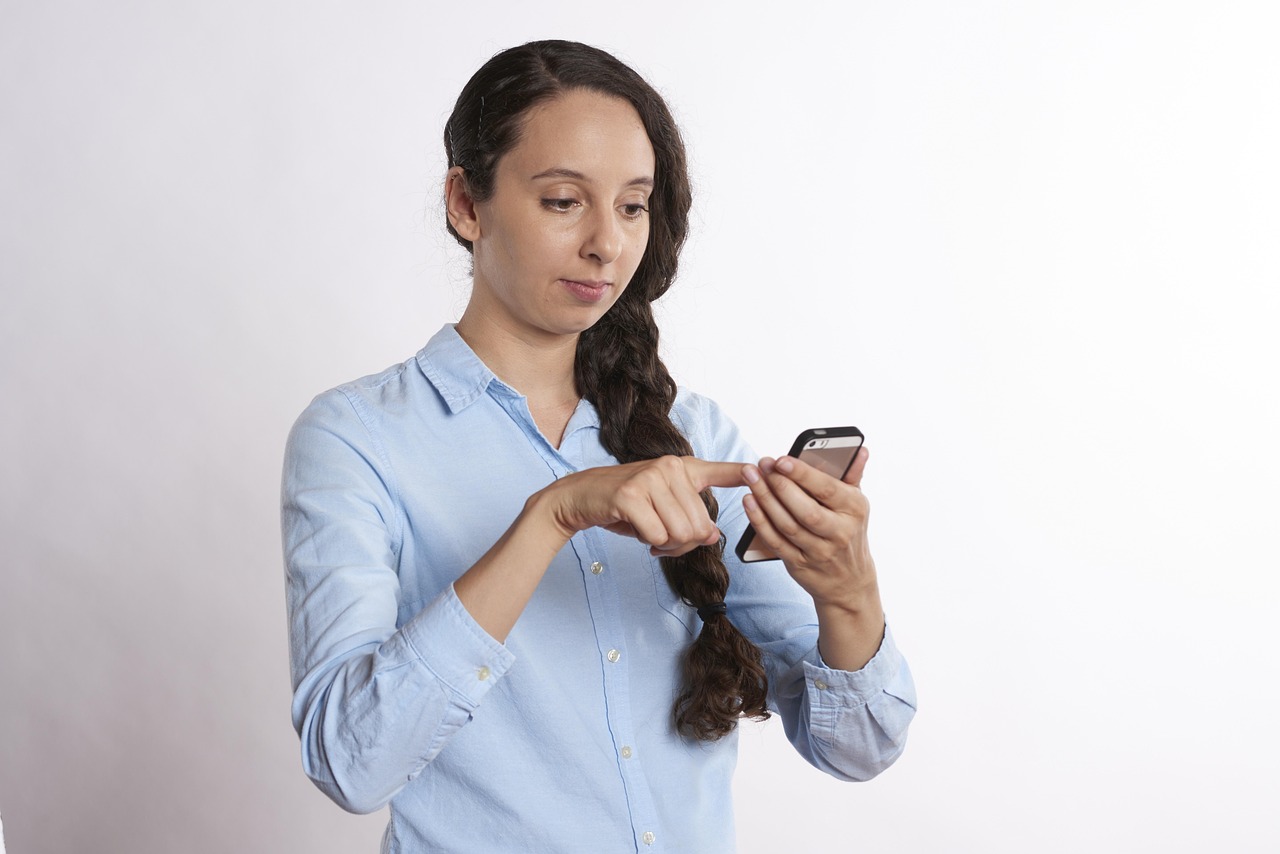 スマートフォンを指で操作する女性