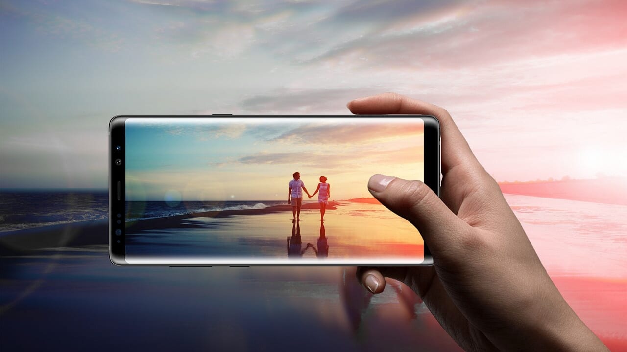 海辺の写真を表示したスマートフォンを手に持っている様子