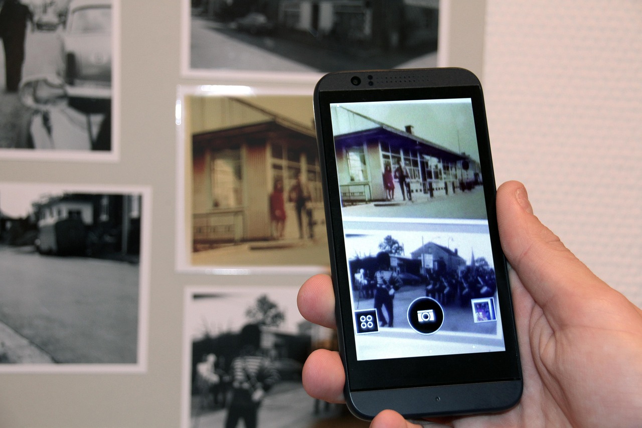 壁に飾られた古い写真と、それを映したスマートフォンの画面
