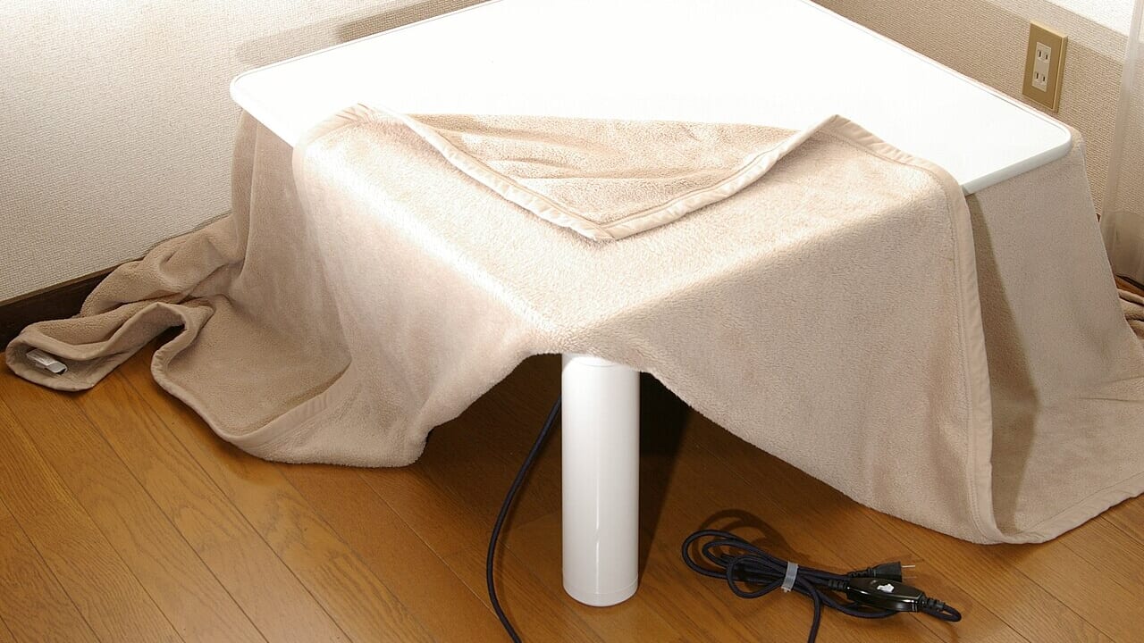 布団をかけた電気こたつと、床に伸びた電源コード