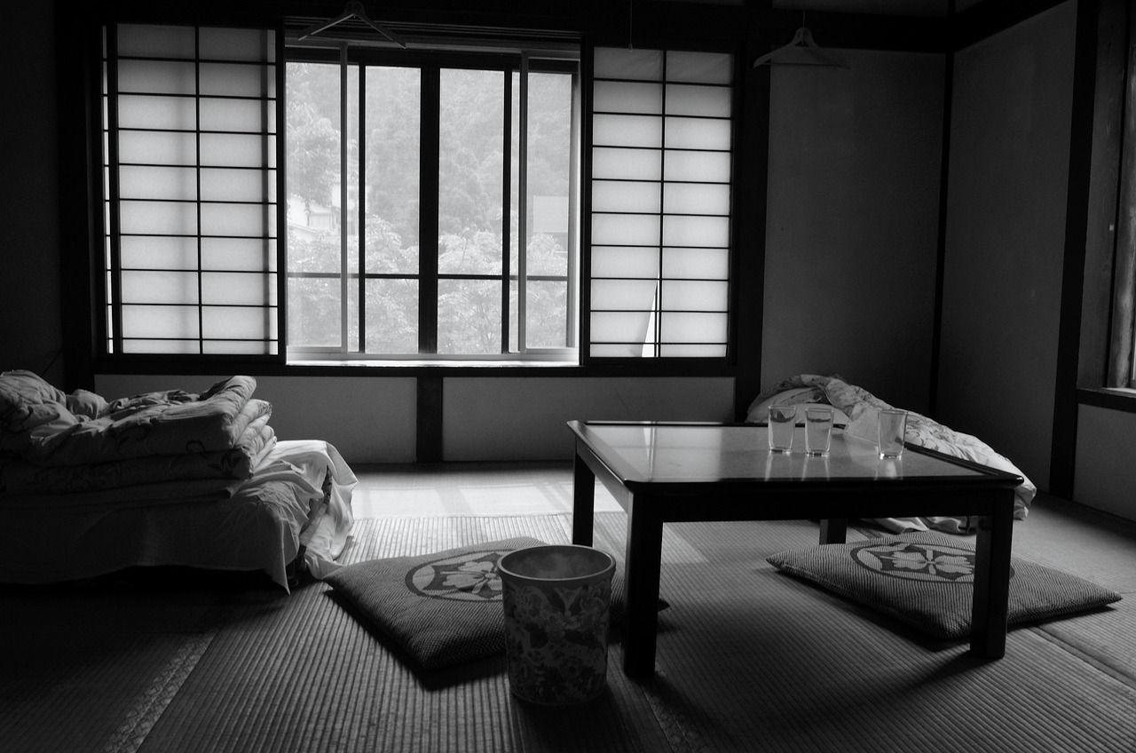 布団と座卓、座布団が置かれた畳の和室(白黒写真)
