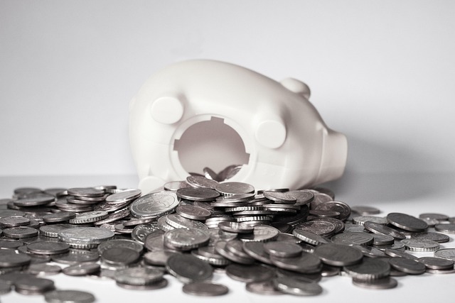 貯金箱から硬貨がこぼれ出ている写真、企業や家計のお金の動きをイメージ