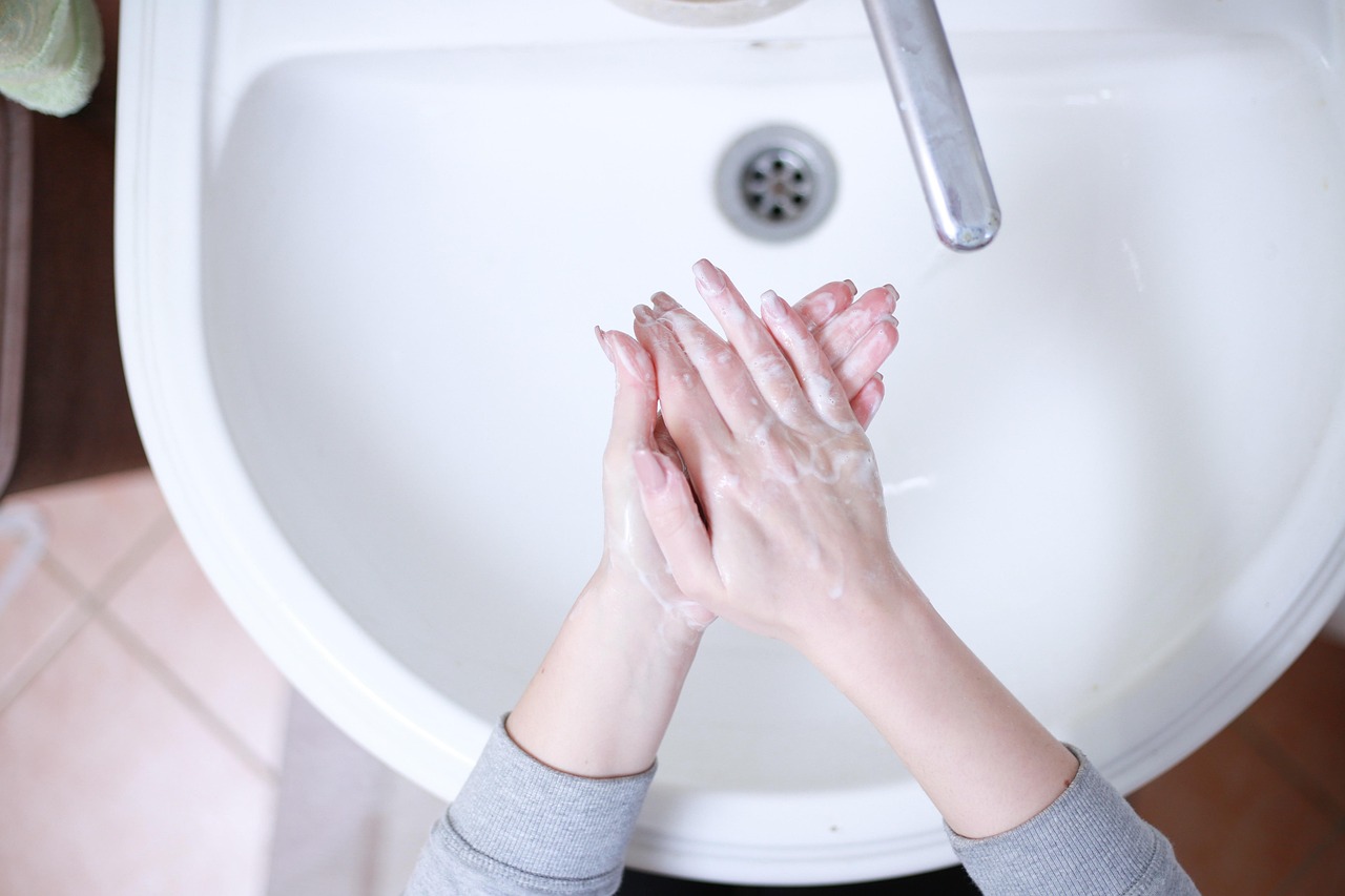 洗面台で石けんを泡立てて手を洗う様子