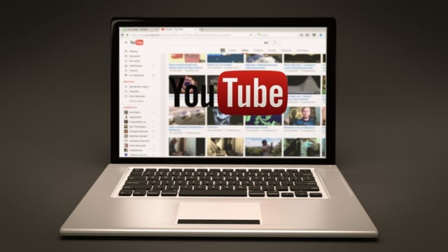 ノートパソコンの画面にYouTubeのロゴと動画の一覧が映っている