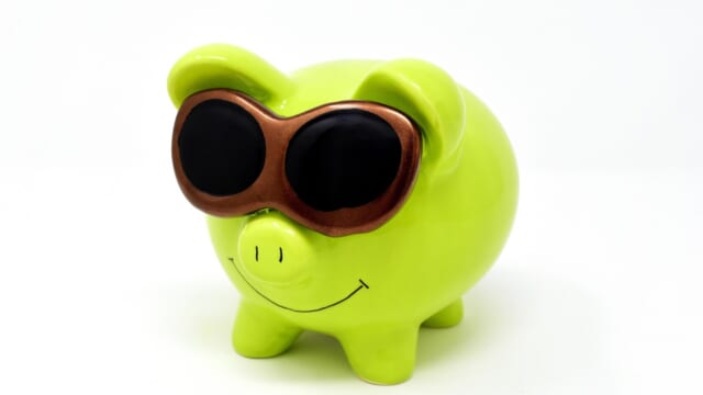 サングラスをかけた緑の豚の貯金箱