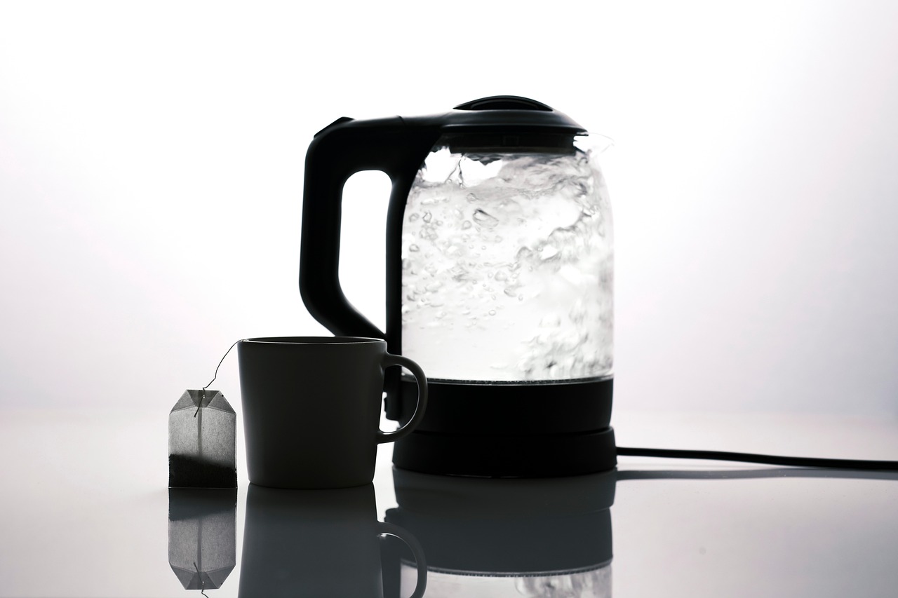 ガラスの電気ケトルでお湯が沸いている様子とマグカップ